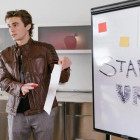 Mann steht vor einem Flipboard, auf dem Start-up steht.