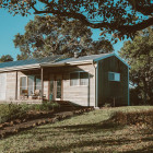 Holzhaus nahe grünen Bäumen unter blauem Himmel